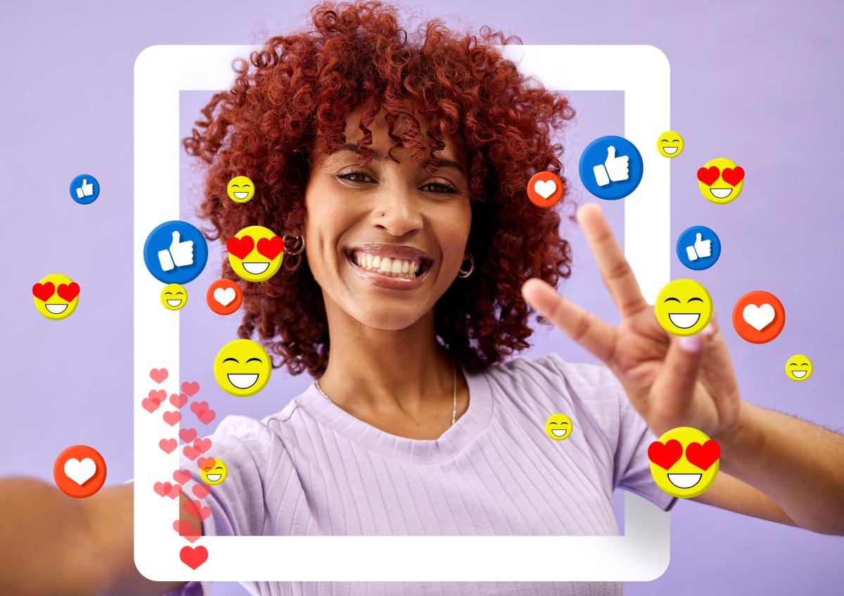 A happy woman taking a selfie, surrounded by social media reactions like likes and hearts. She’s smiling and showing a peace sign.