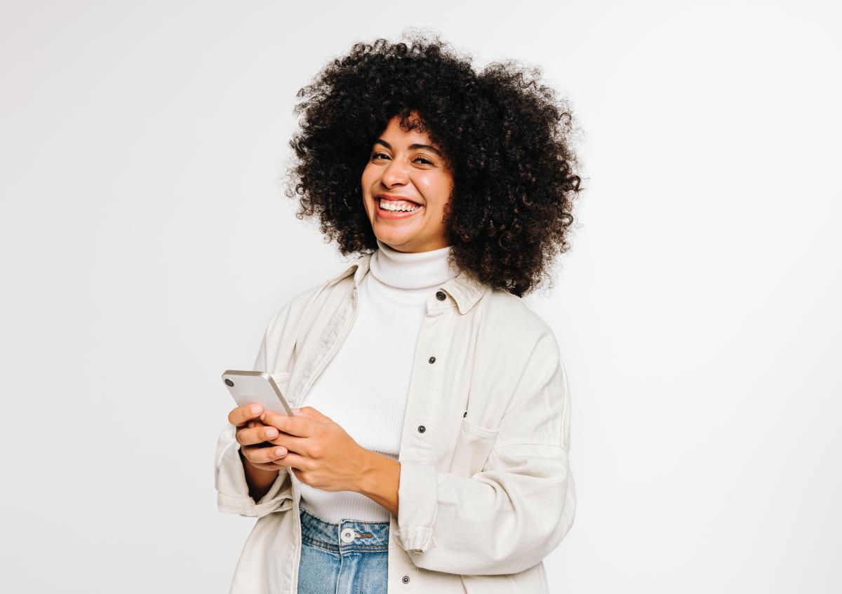 Smiling woman holding a smartphone and looking happy