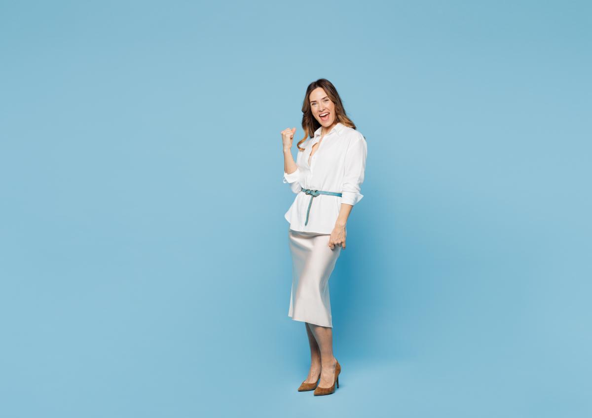 A woman looking very happy and excited. She’s making a fist with one hand as a sign of celebration or success