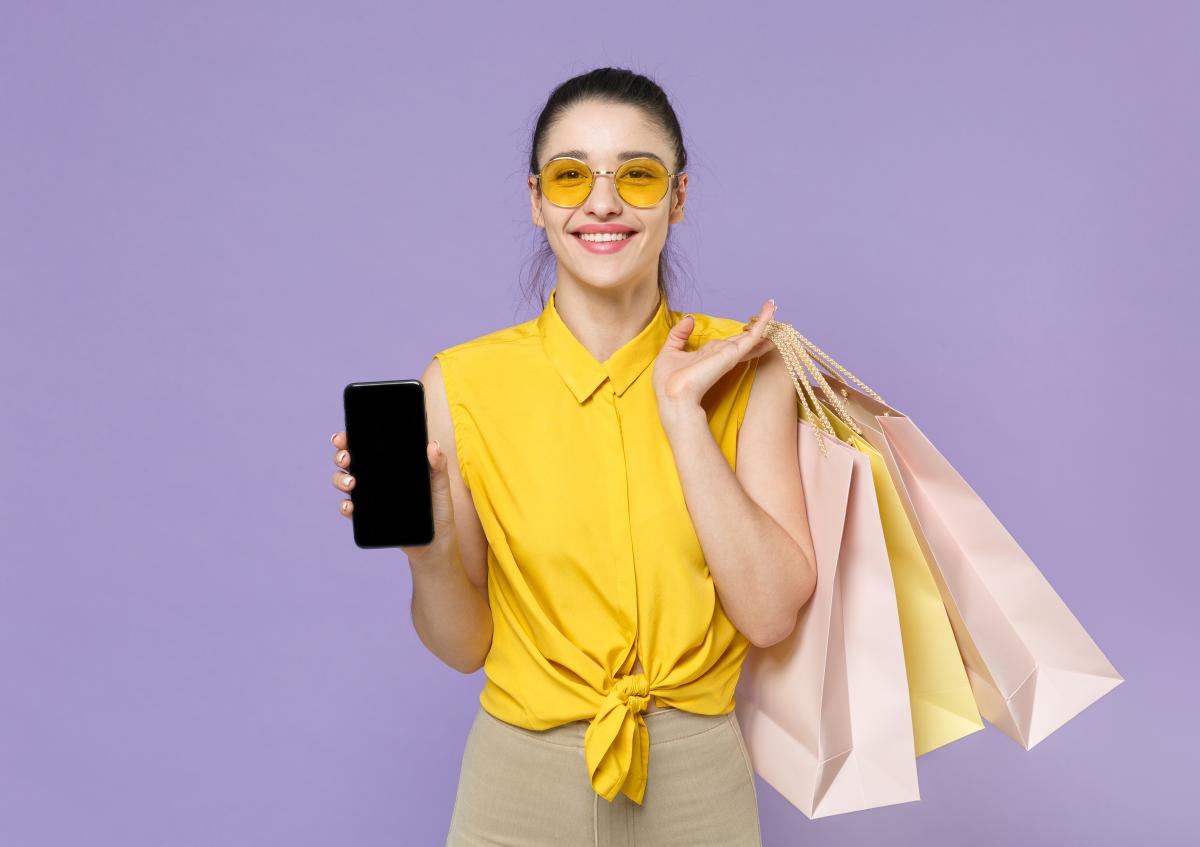 Vrouw met winkeltassen houdt telefoon vast, achteraf betalen