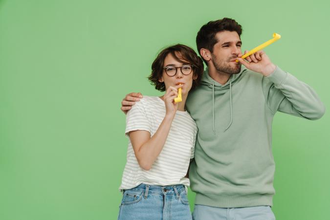 Man and woman with party horns