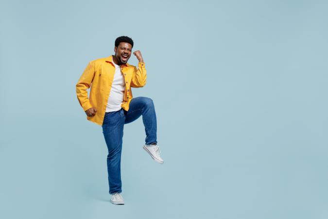 Man met geel jack juicht omdat hij het volledige bedrag terugkrijgt